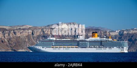 Fira, Griechenland - 16. Juli 2019: Die itailan basierte Kreuzfahrtschiff Costa Luminosa im Ägäischen Meer vor der Küste von Santorini in der Nähe der Fira verankert Stockfoto