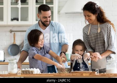 Ehepaar und Kinder pie Vorbereitung in der Küche zu Hause. Stockfoto