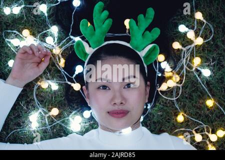 Schöne Mode Stil der vietnamesischen Frauen - Porträt der asiatischen schöne Mädchen beste Freunde liegen auf bunte Lichter auf dem Gras Stockfoto