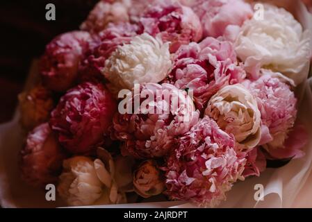 Blumenstrauß aus rosa und weißen Pfingstrosen, dunklen Moody Hintergrund. Stockfoto