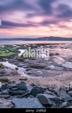 Nach einem kalt, aber trocken Nacht in North Devon, bei Sonnenaufgang eine sanfte Brise gibt einen Schauer in der Luft, und die Dämmerung Himmel dreht Pink über die malerische Küste Stockfoto