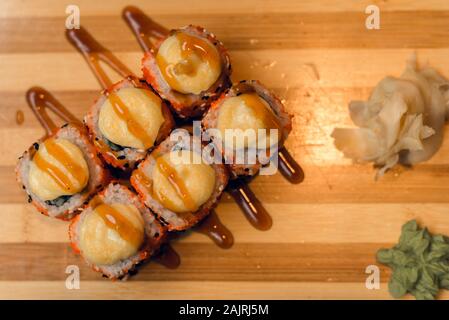 Eingestellt von warmen Brötchen auf einer hölzernen Fach mit Ingwer und Wasabi. Lecker Sushi in einem chinesischen Restaurant. Stockfoto