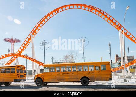 Classic yellow School Bus vor der Thunderbolt rollercoaster Theme Park Fahrt auf Coney Island, Brooklyn, New York, United States geparkt Stockfoto