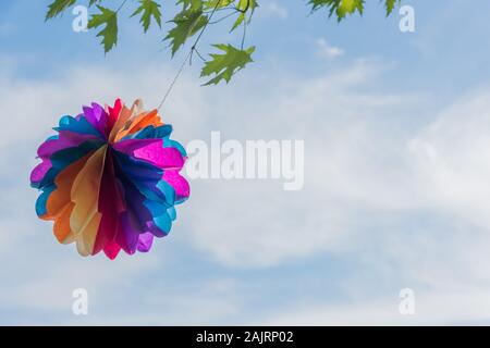 Ein Papier Ballon hängt an einem Zweig vor blauem Himmel Stockfoto