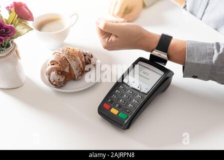 Mann mit smart Watch im Restaurant zu bezahlen. NFC contactless bequeme Zahlung Service Stockfoto