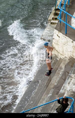 Einsame weibliche betrachtet ihre Meer schwimmen Stockfoto