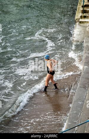 Einsame weibliche betrachtet ihre Meer schwimmen Stockfoto