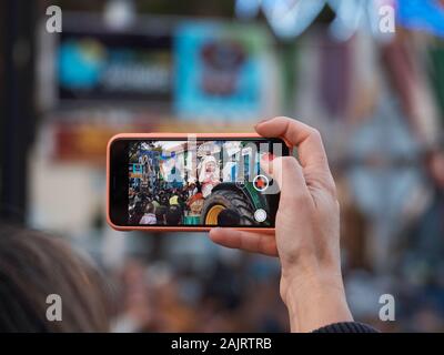 Aufzeichnen von Videos mit einem Smartphone der Drei Könige Parade in Fuengirola, Málaga, Spanien. Stockfoto