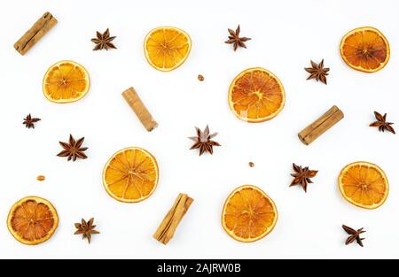 Konzept von Weihnachten. Blick von oben auf die Muster mit getrockneten Orangenscheiben, Zimt und Anis auf weißem Hintergrund. Winter Zusammensetzung. Stockfoto
