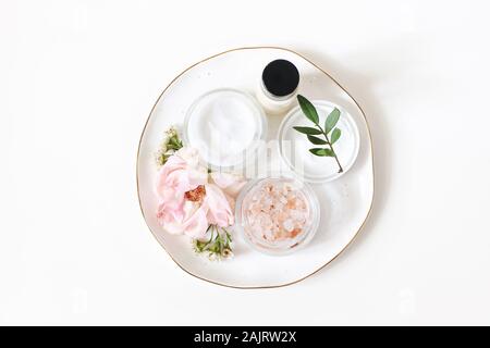 Styled Schönheit der Komposition. Haut Creme, Shampoo Flasche, rose Blumen und Himalaya Salz. Weißem Hintergrund. Bio Kosmetik, spa-Konzept. Leer Stockfoto