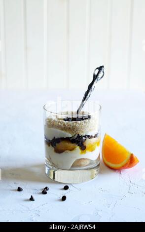 Konzept der italienisches Essen. Orange Tiramisu, italienische Dessert von finger Keks- und Mascarpone in einem Glas auf weißem Hintergrund. Stockfoto
