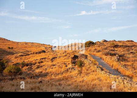 Griechische Insel Landschaft, im Herbst am Nachmittag, Gold chemische Pflanzen und Felsen, leere Pfade und Stone Paddocks, sonnigen Tag im Herbst und klaren blauen Himmel Stockfoto