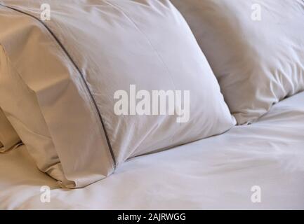 Hotel Zimmer Bett Interior Detail. Weiße Bettwäsche und Kissen, Nähe zu sehen. Stockfoto