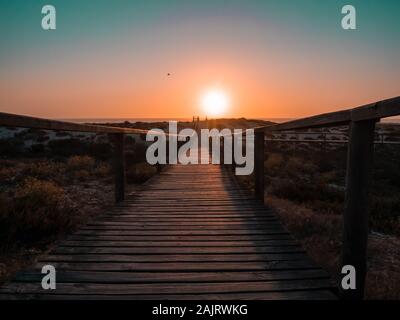 Holzsteg in Richtung Sonnenuntergang Stockfoto