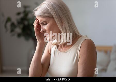 Ungesunde ältere Frau mit Migräne zu Hause Stockfoto