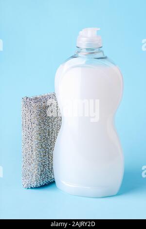 Weiß Geschirrspülmittel in einem transparenten Kunststoff Flasche und Silber Schaum Schwamm. Reinheit und Haushaltschemikalien. Küche Reinigungsmittel. Auf einem Pastell blau. Stockfoto