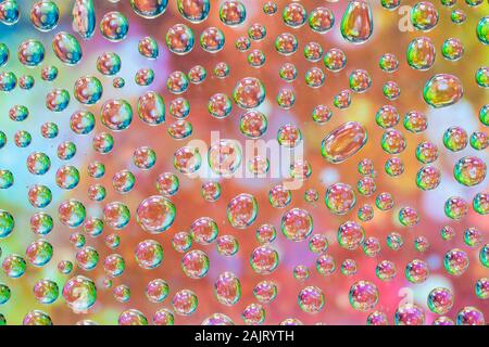 Wassertropfen auf Glas mit bunten Pastelltönen Reflexionen - strukturierten Hintergrund Stockfoto