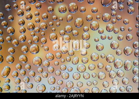 Wassertropfen auf Glas mit bunten Pastelltönen Reflexionen - strukturierten Hintergrund Stockfoto