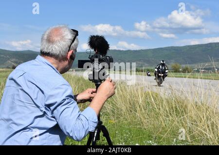 Älterer mann Videoaufnahmen von Motorrad Racing mit seiner digitalen Kamera auf Stativ. Amateur Rennen auf dem ehemaligen Flughafen Landebahn, Sliven, Bulgarien Stockfoto