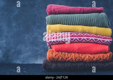 Stapel aus Gewirken aus Wolle pullover Herbst Farben. Kleidung mit verschiedenen Strickmuster im Stapel gefaltet. Warmen gemütlichen Winter fallen Strickwaren Konzept. Kopieren Stockfoto