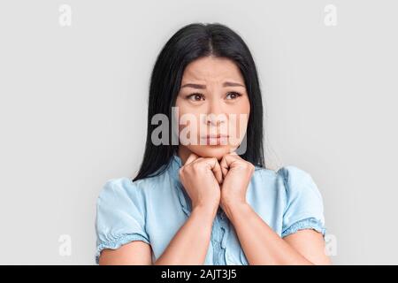 Freestyle. Asiatische Frau stehen auf weißen Suchen beiseite traurig schließen isoliert - oben Stockfoto