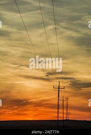 Bunte Wolken nach dem Sonnenuntergang und elektrischen Polen Stockfoto