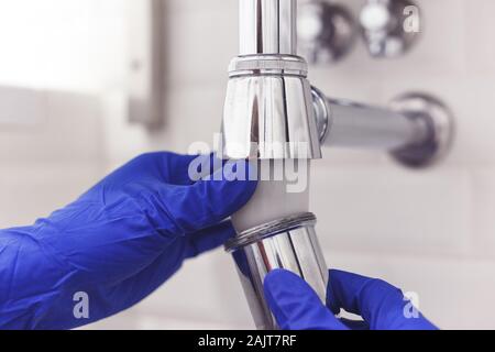 Klempner Reparaturen und pflegt Chrom Düker unter dem Waschbecken. Klempner in Bad, Sanitär-Konzept zusammen- und einbauen Stockfoto