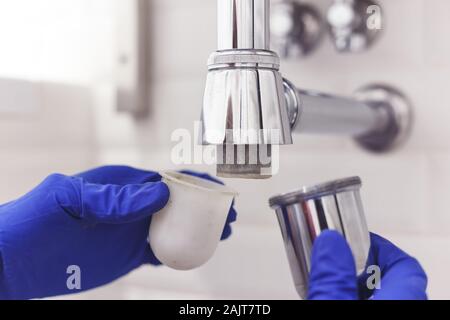 Klempner Reparaturen und pflegt Chrom Düker unter dem Waschbecken. Klempner in Bad, Sanitär-Konzept zusammen- und einbauen Stockfoto