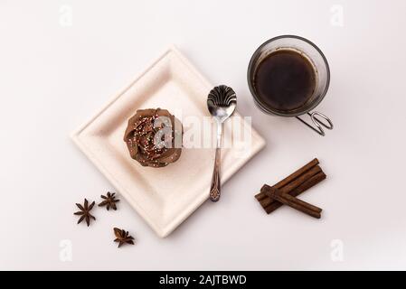 Chocolate Muffin mit heißen Tasse Kaffee, Zimtstangen und Anis Sterne auf einem weißen Hintergrund, Ansicht von oben Stockfoto