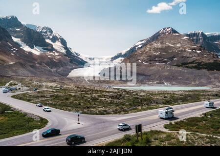 Blick auf den Athabasca Gletscher mit Fahrzeugen, die von der berühmten Icefield Parkway Route zwischen Jasper und Banff National Park in Alberta, Kanada fahren. Stockfoto