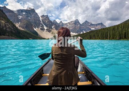 Weibliche touristische Kanufahren auf Moraine Lake im Banff National Park, der Kanadischen Rockies, Alberta, Kanada. Stockfoto