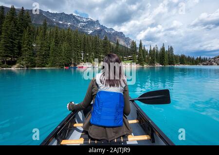 Touristische Kanufahren auf Moraine Lake im Sommer im Nationalpark Banff, Canadian Rockies, Alberta, Kanada. Stockfoto