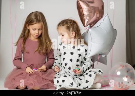 Nahaufnahme, Porträt von zwei Schwestern, 7 Jahre alt Blond Kleinkind Mädchen und ein 3 Jahre altes Baby, Schwestern, beste Freunde, Happy Family Konzept. Stockfoto