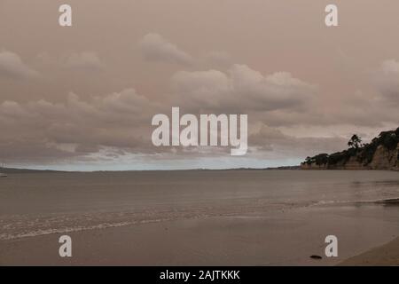 Neuseeland, Nordinsel - 5. Januar 2020: Der Blick auf ein Dunst in den Himmel von Australiens Buschbrände hängt über Torbay Beach, North Shore Bezirk Stockfoto