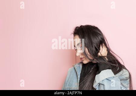 Portrait von glücklich aus dem Nahen Osten weibliche gegen einen rosa Hintergrund posiert. Studio Portrait einer stilvollen junge Frau. Schönheit, Mode, saisonale Vogue Stockfoto