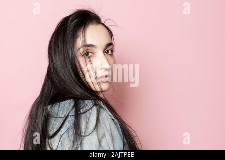 Portrait von glücklich aus dem Nahen Osten weibliche gegen einen rosa Hintergrund posiert. Studio Portrait einer stilvollen junge Frau. Schönheit, Mode, saisonale Vogue Stockfoto