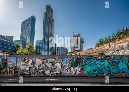 LONDON, Großbritannien - 18 September: Graffiti bedeckt Wand in Shoreditch mit finanzviertel Stadt Gebäude in der Ferne am 18 September, 201 Stockfoto