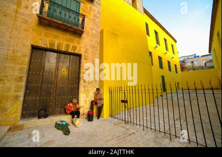 Zwei Musiker neben einem gelben wand in Havanna, Kuba Stockfoto