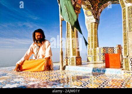 Sadhu kümmert sich um einen Tempel auf der Oberseite des Girnar Hill Stockfoto