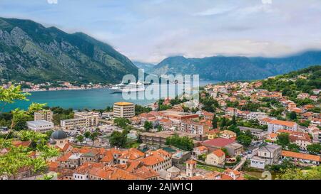 Die malerische Altstadt von Kotor, Montenegro, und seine lange Bucht und die umliegenden Berge, als Kreuzfahrtschiff in den geschützten Hafen. Stockfoto