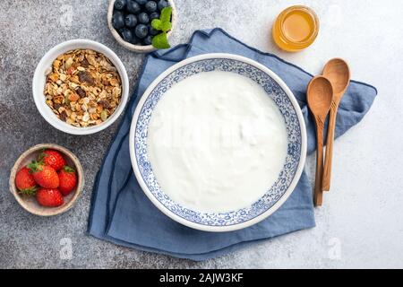 Joghurt Schüssel, frische Beeren Müsli Müsli und Honig. Gesundes Frühstück essen, kopieren Schränke, Ansicht von oben Stockfoto