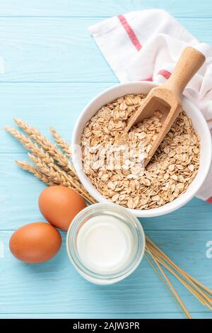 Hafer, Milch und Eier auf blauem Hintergrund. Gesundes Frühstück essen, Diät Konzept Stockfoto