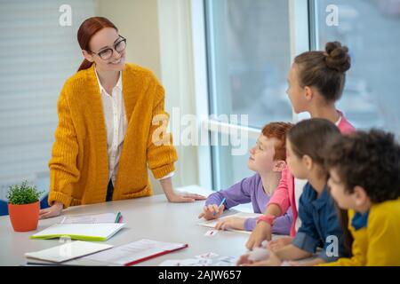 Lächelnd Lehrer arbeiten mit Grundschüler Stockfoto