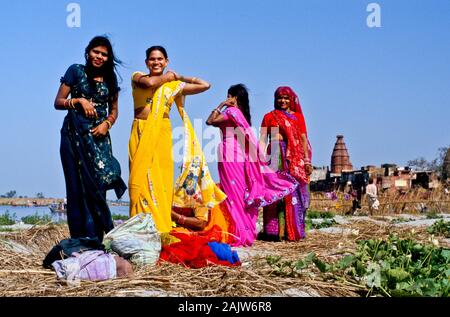 Frauen ändern Saris nach einem Bad im Fluss Yamuna Stockfoto