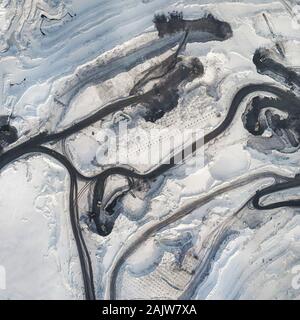 Winter Steinbruch Ansicht von oben. Luftaufnahme der Winter Steinbruch. Straßen mit Mining Equipment im Winter Blick von oben. Stockfoto