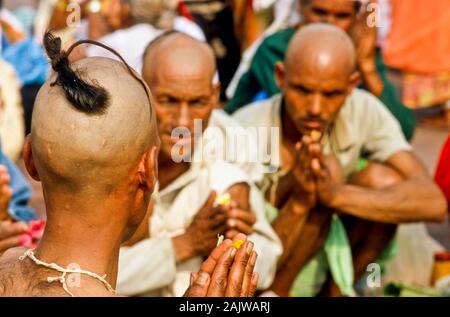 Ein Priester ist die Unterstützung von Beten Ritual für die gute Reinkarnation eines verstorbenen Person an Har-Ki-Pauri-Ghat in Haridwar Stockfoto