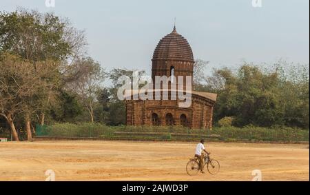 Bishnupur, Westbengalen/Indien - 7. Februar 2018: Ein Mann auf einem Fahrrad fährt am alten Hindu-Tempel von Nandalal vorbei. Stockfoto