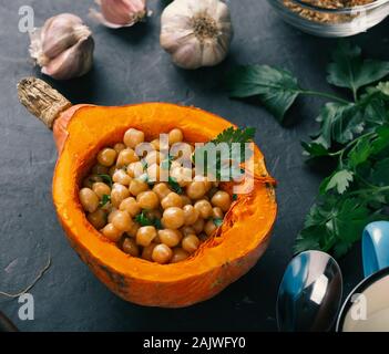 Curry Kichererbsen gebacken in einer Platte von hokkaido Kürbis. Stockfoto