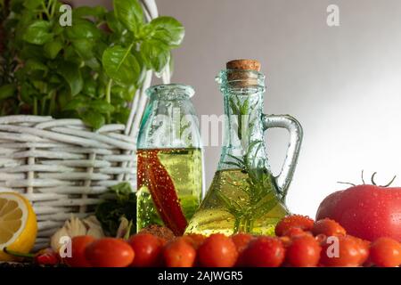 Flaschen mit gewürzten Öl. Schmeckt nach Italien. Basilikum, Pfeffer und Knoblauch. Vorbereitung einen Salat.. Tomaten und Aromen der Pizza. Stockfoto