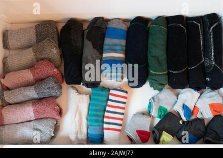 Die vielen bunten Männer Socken in einem schlichten weißen Holz- Socke Fach in einem grossen Schrank Stockfoto